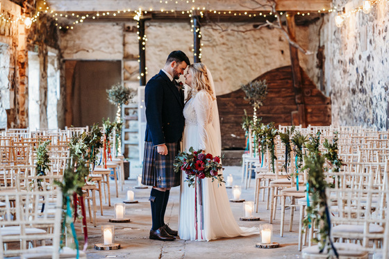 Bride and groom stand touching foreheads in ceremony room Pratis Barns